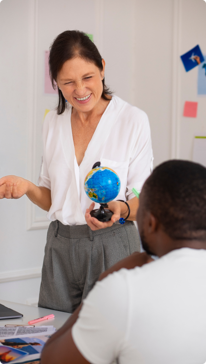 A woman standing talking to a man sitting.